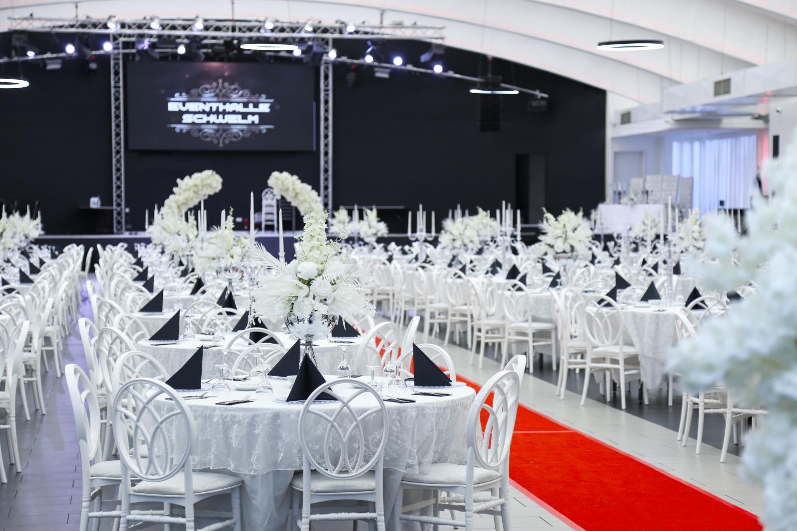 Eventhalle mit rotem Teppich und Bühne